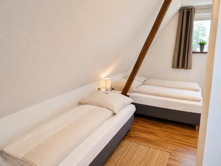 Schlafzimmer im Dachgeschoss mit Doppelbett und Einzelbett