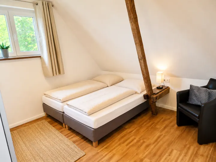 Helles Schlafzimmer mit Doppelbett unter der Dachschräge