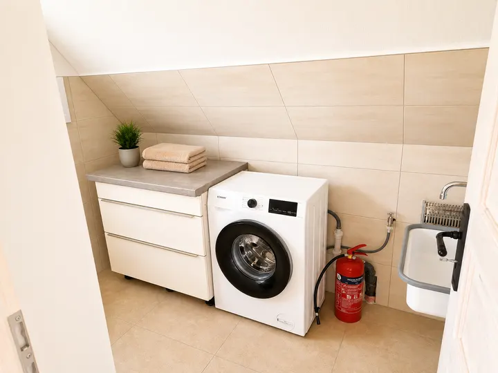 Hauswirtschaftsraum mit Waschmaschine und Waschbecken