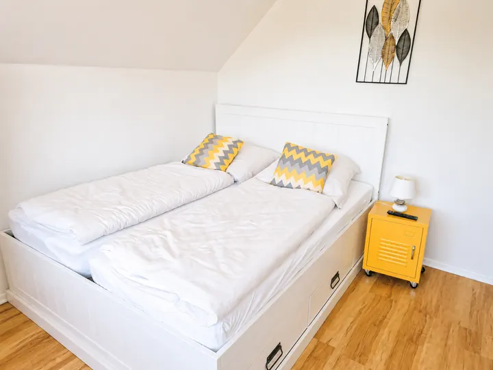 Doppelbett im offenen Wohn- und Schlafbereich von Wohnung 1