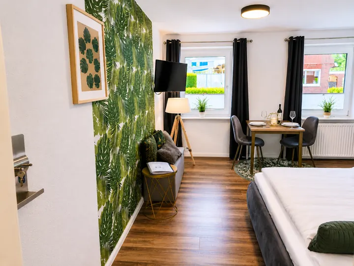 Wohn- und Schlafbereich der Wohnung 3 mit grüner Akzentwand