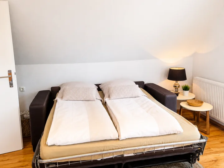 Ausgeklapptes Schlafsofa im Wohnbereich der Wohnung 4