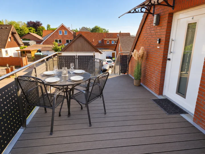 Balkon der Wohnung 4 mit Esstisch und Blick über das Grundstück
