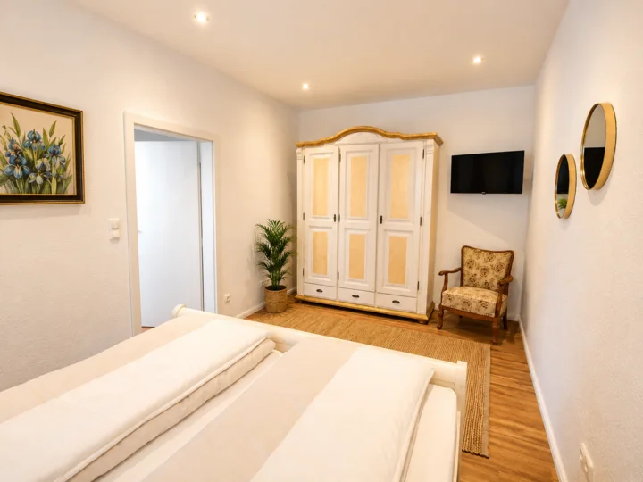 Schlafzimmer in Wohnung 5 mit Doppelbett, Kleiderschrank und Fernseher
