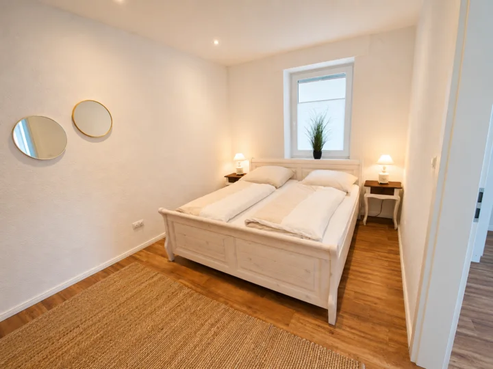 Helles Schlafzimmer der Wohnung 5 mit Doppelbett