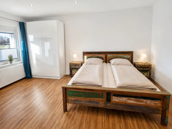 Schlafzimmer der Wohnung 6 mit Doppelbett und großem Kleiderschrank