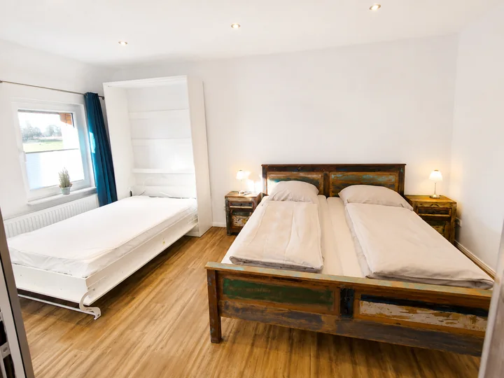 Schlafzimmer der Wohnung 6 mit ausgeklapptem Schrankbett zusätzlich zum Doppelbett